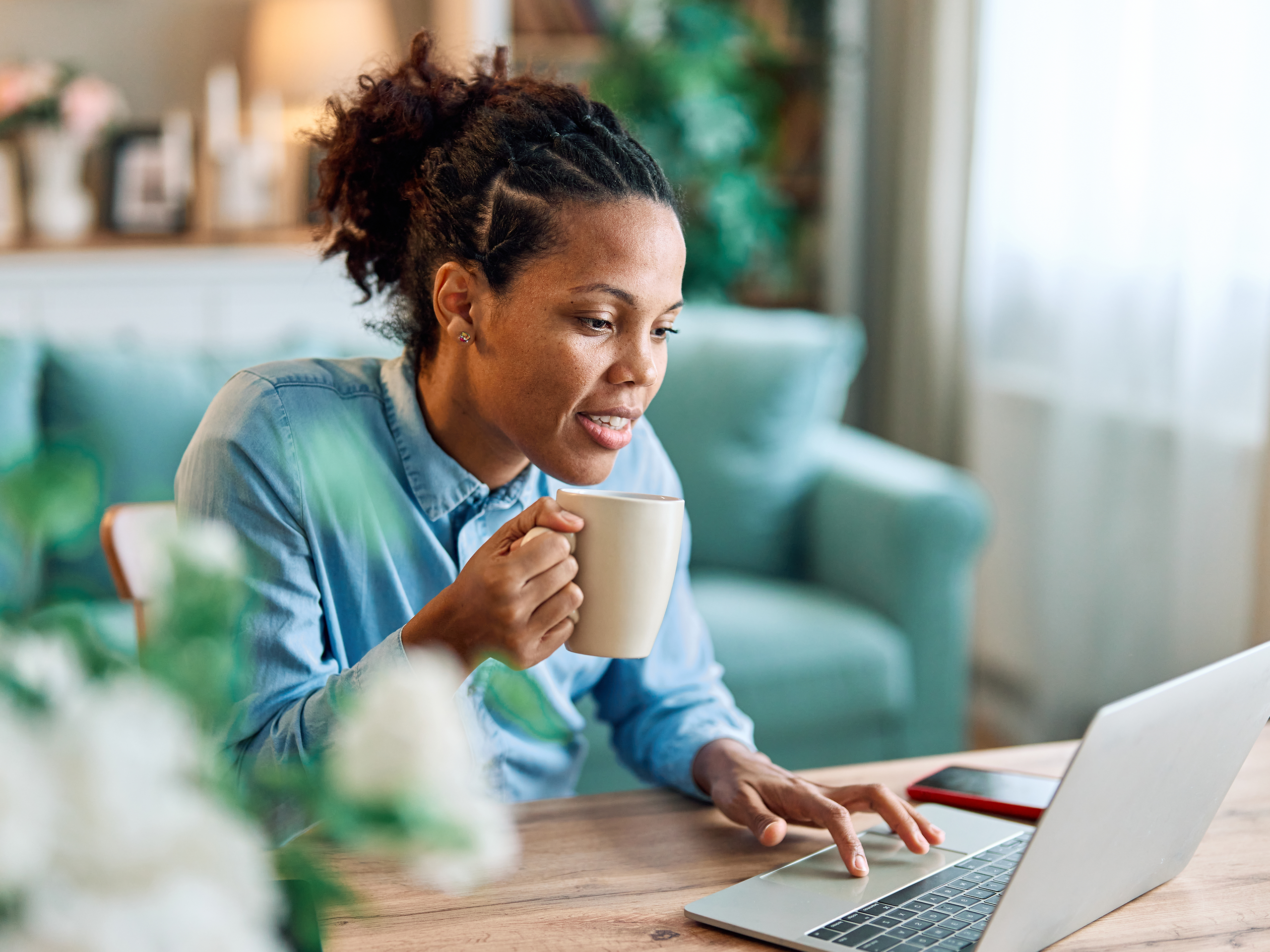 Woman looks at her insurance policy wording on her laptop at home