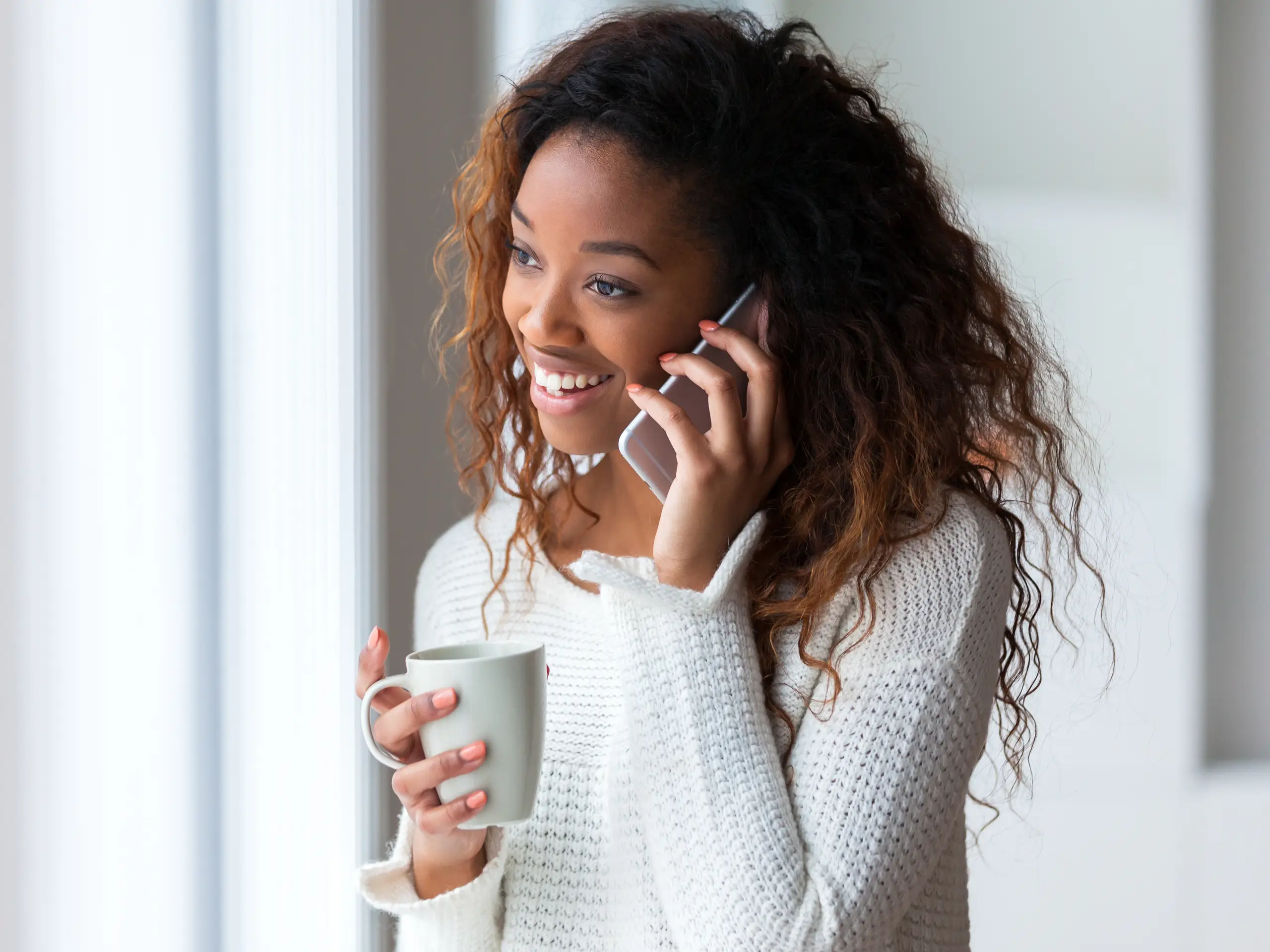 Woman on the phone happy with advice she is being given.