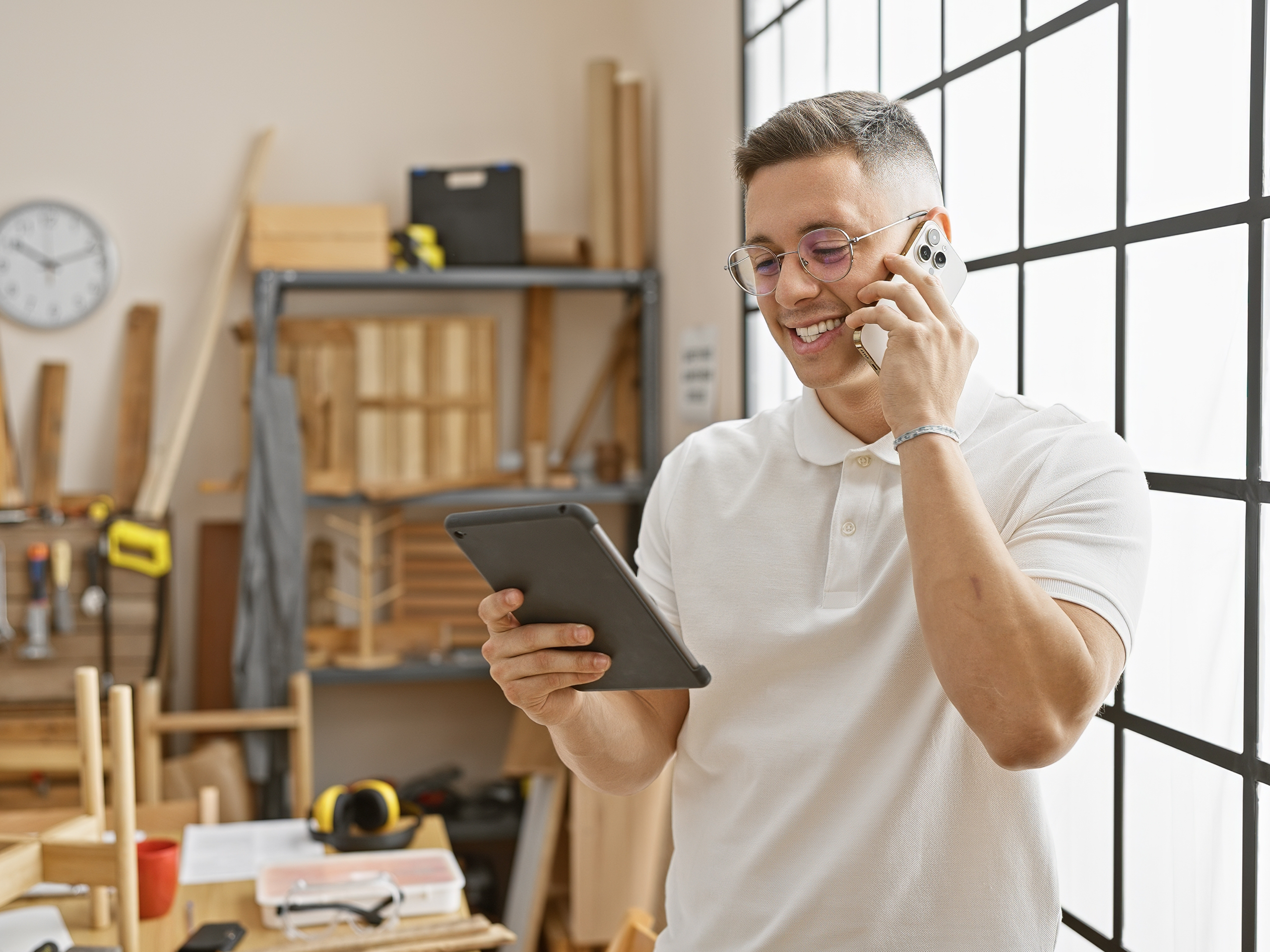 Busines owner talking at phone to ARAG, looking at the tablet