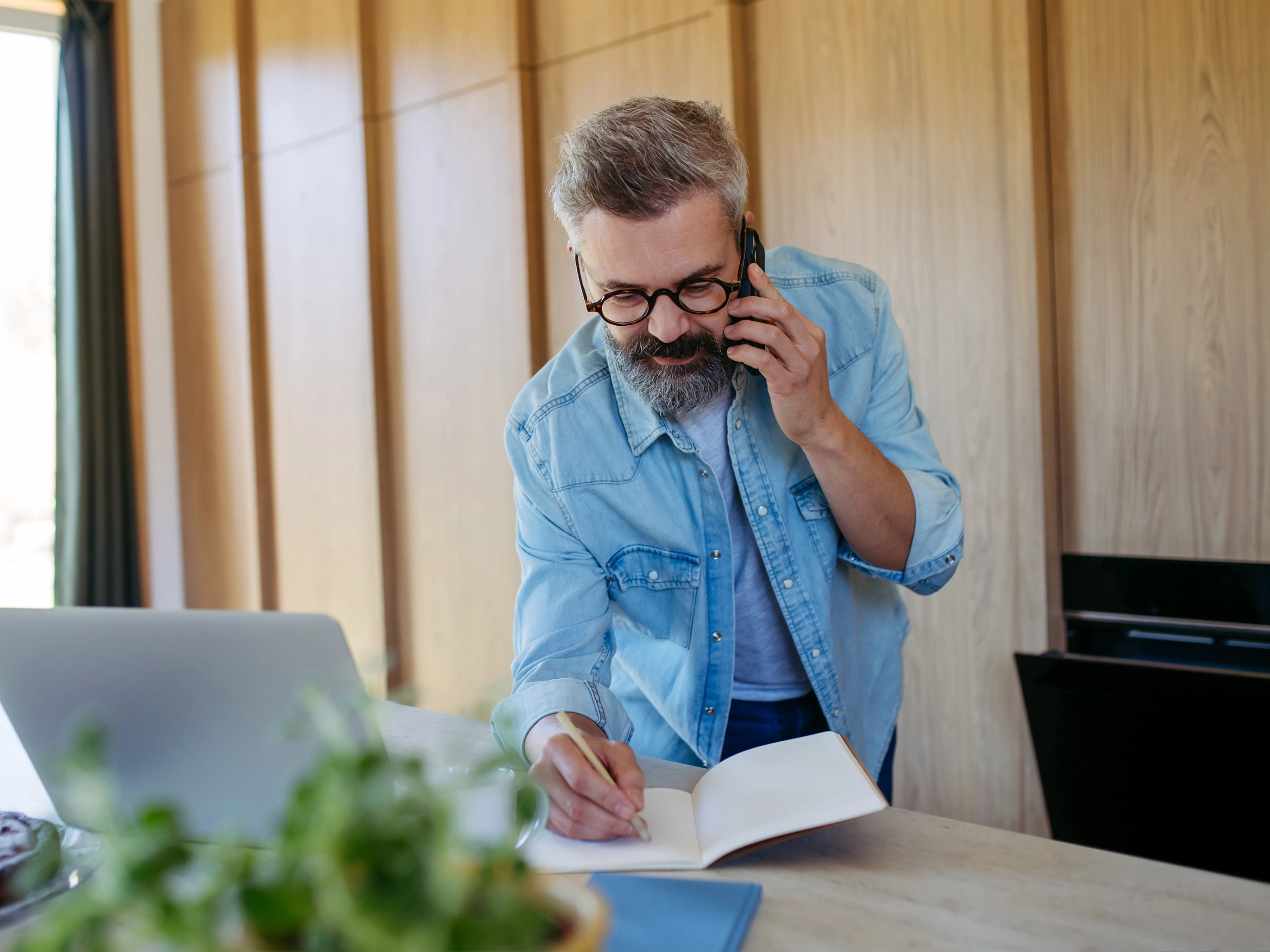 Man writing notes during phone call