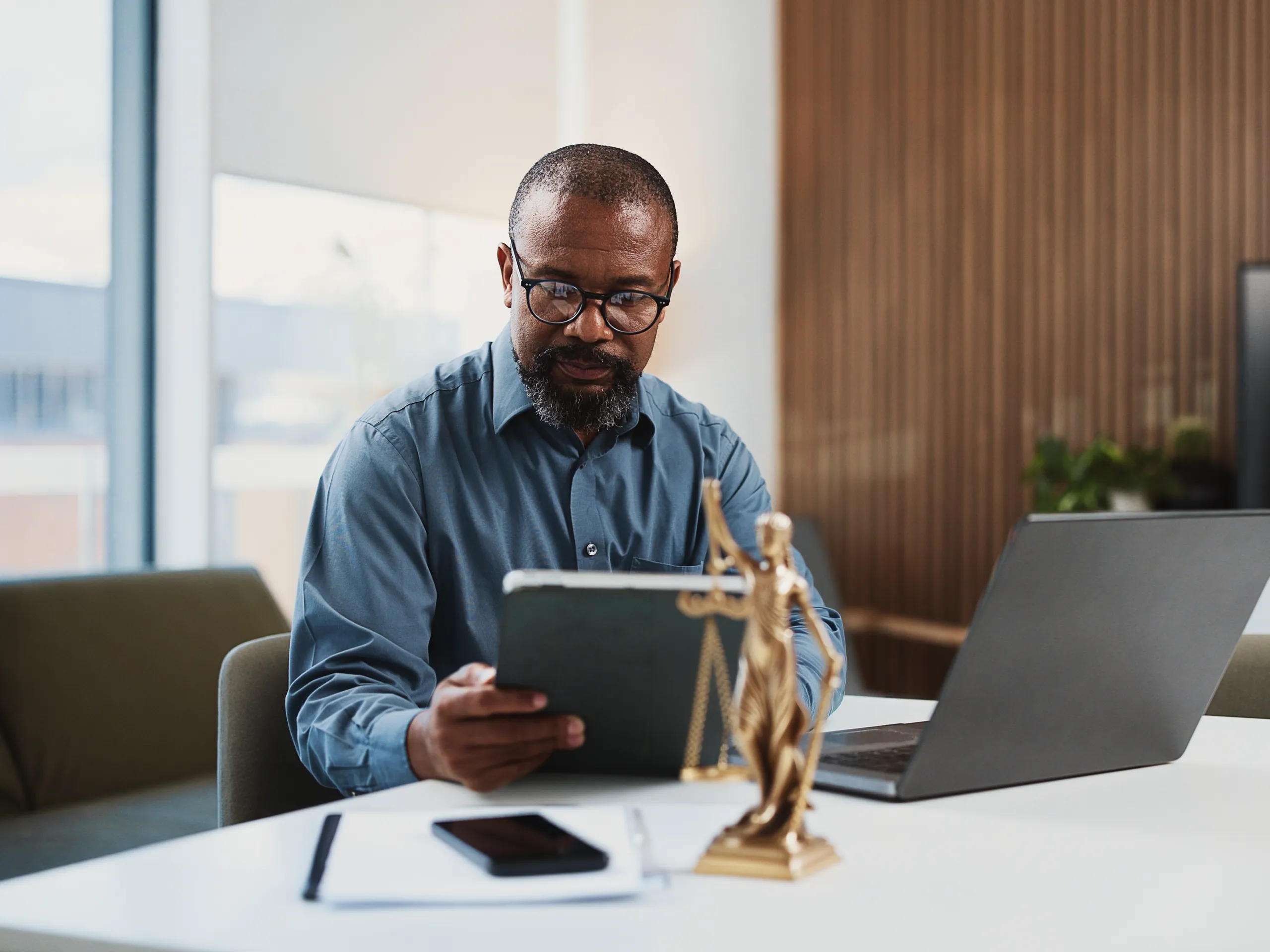 Black man, working with tablet and laptop