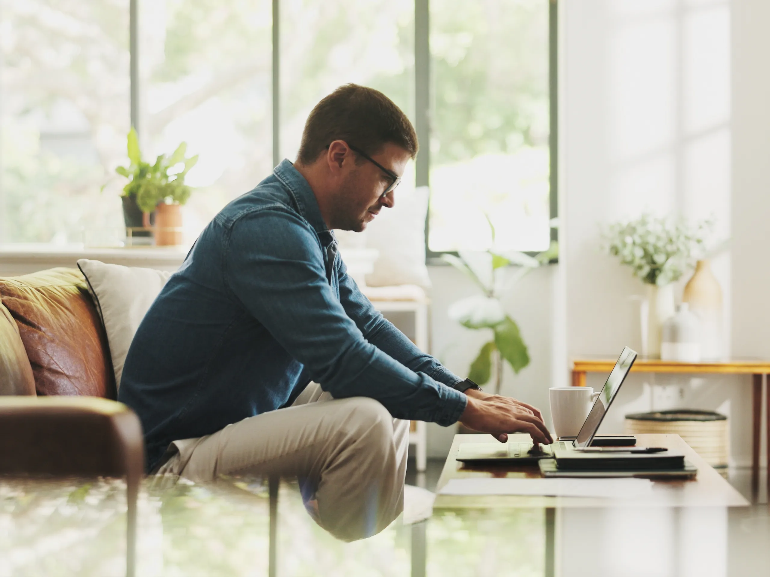 Business man sat on a sofa and working at laptop