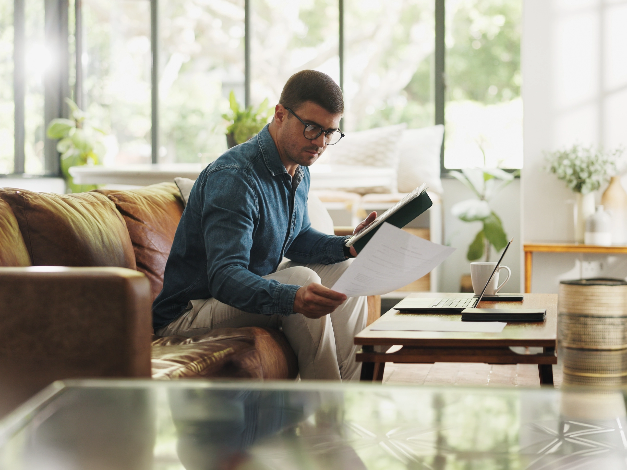 Business man sat on a sofa and checking paperworks 