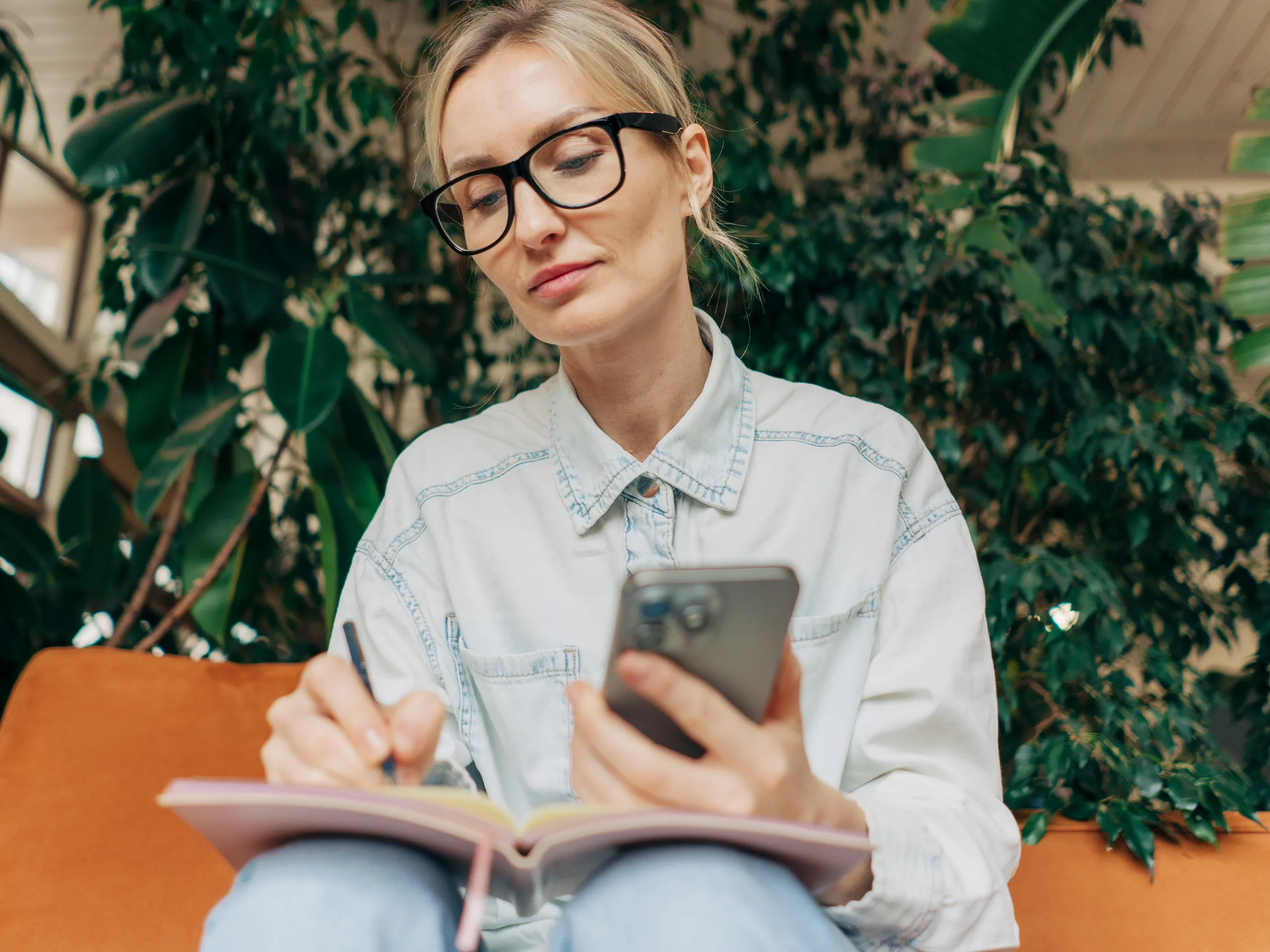 Blond business woman taking notes