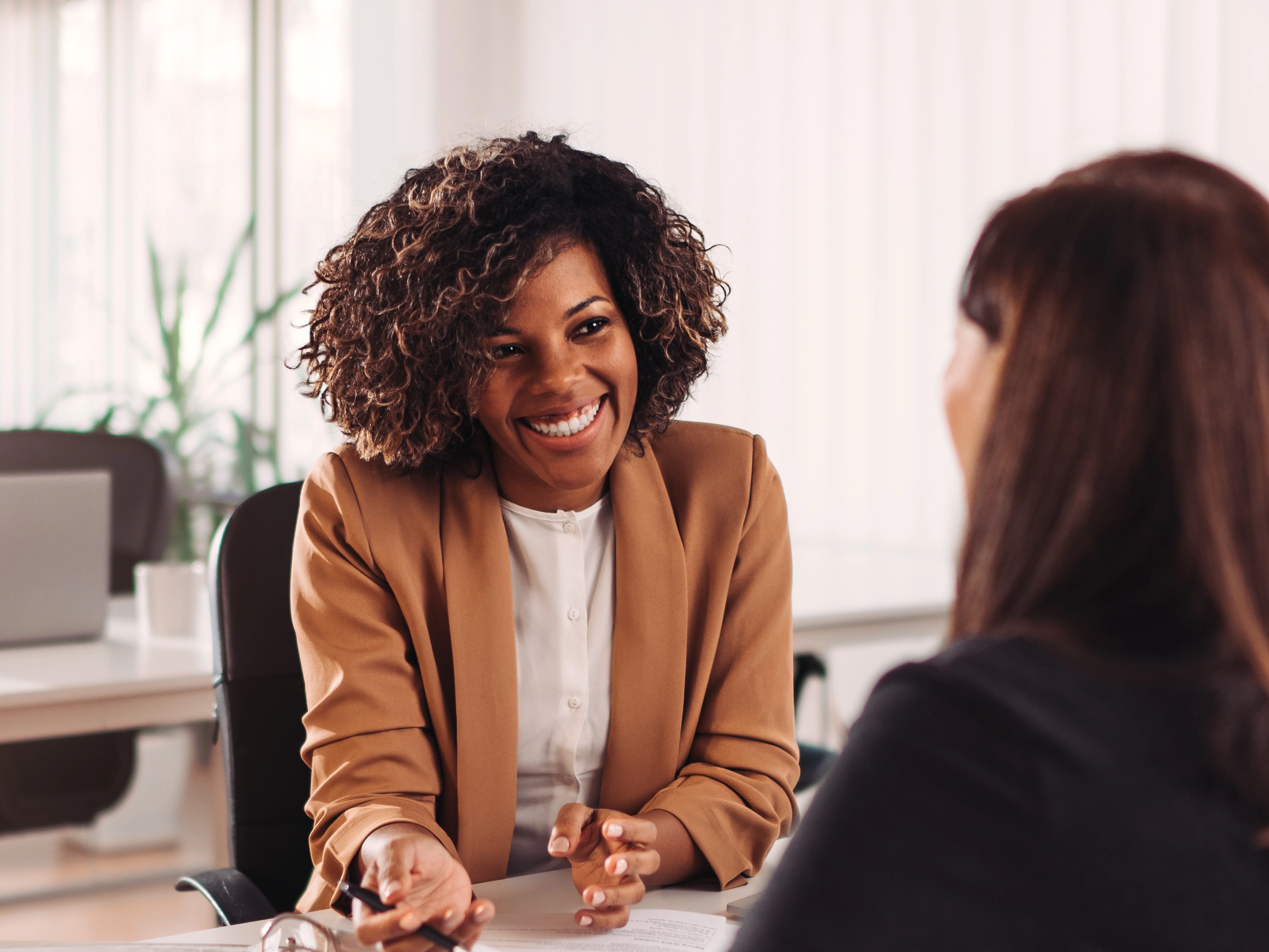 Two people meeting seated discussing face to face in office