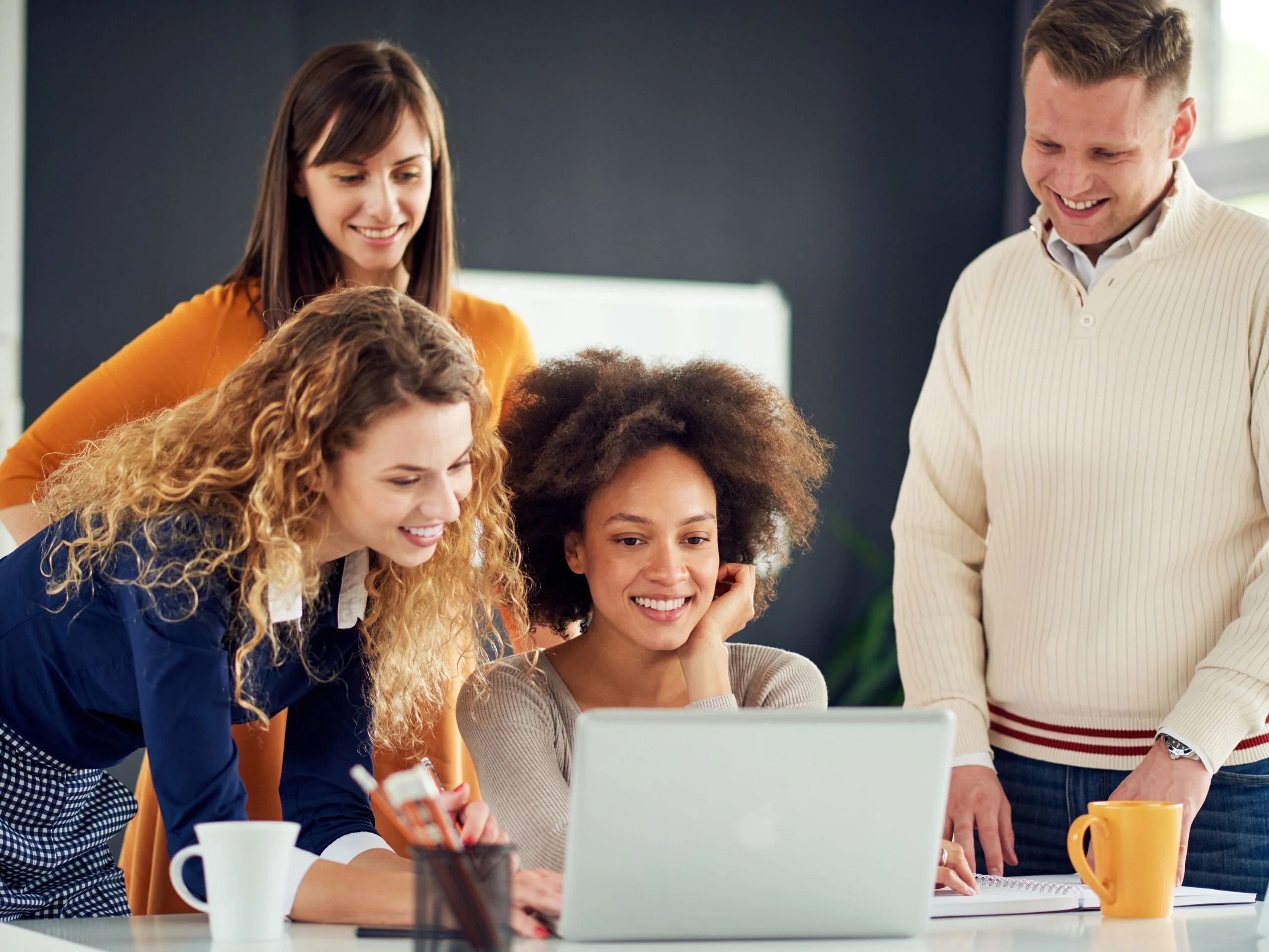 Group of colleagues looking at laptop