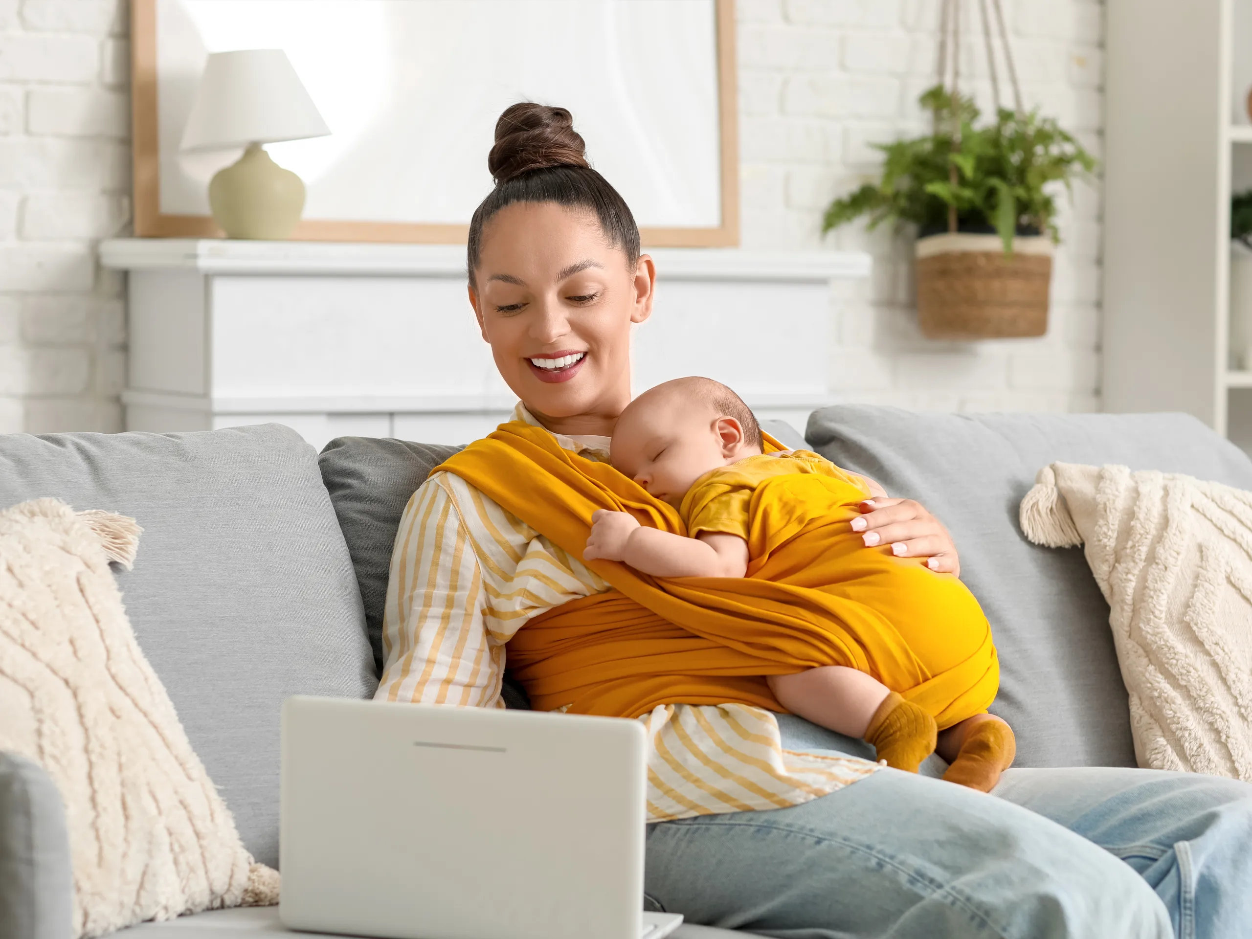 Woman sat on her sofa holding her baby