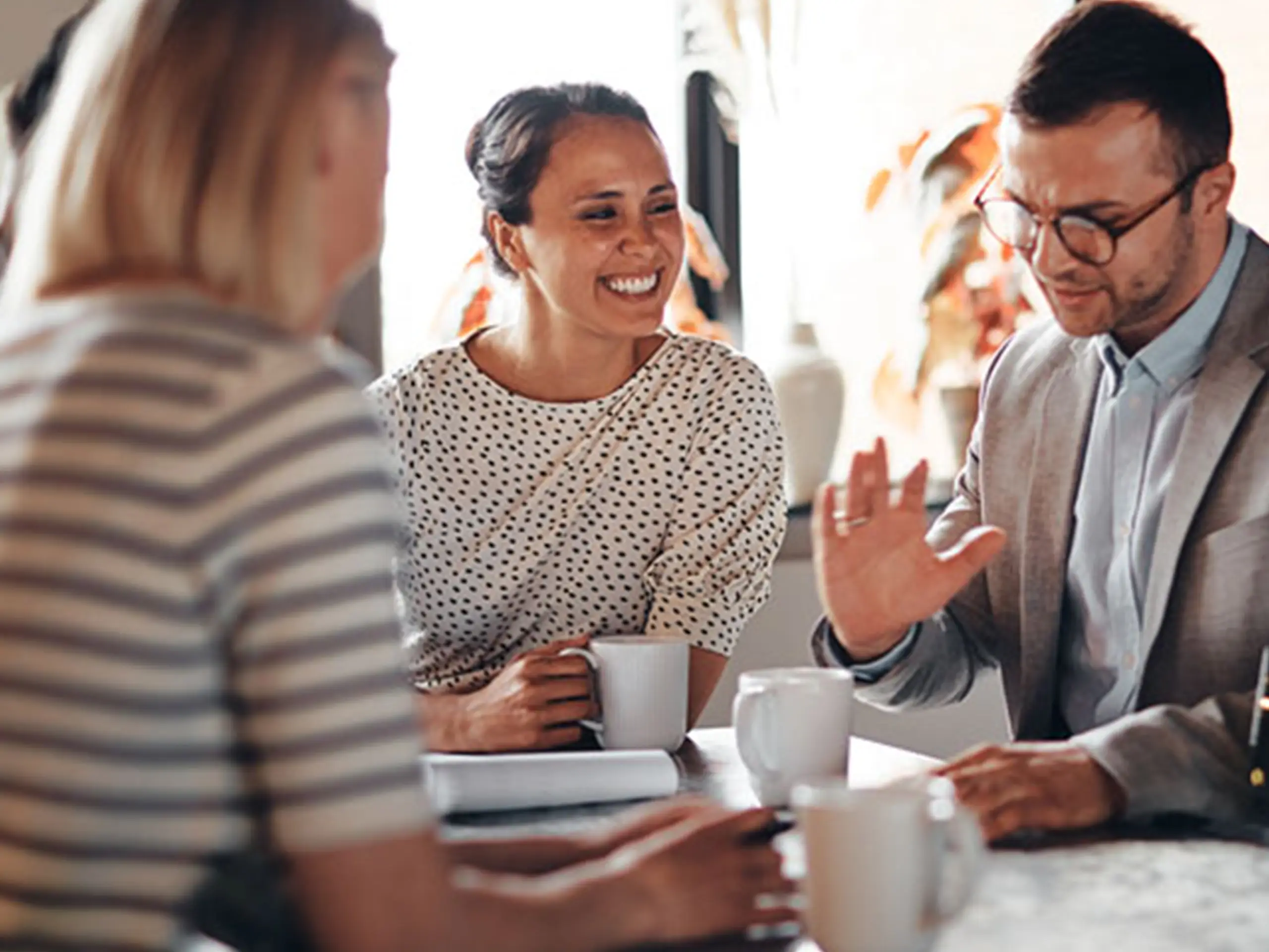 three people chatting round a table