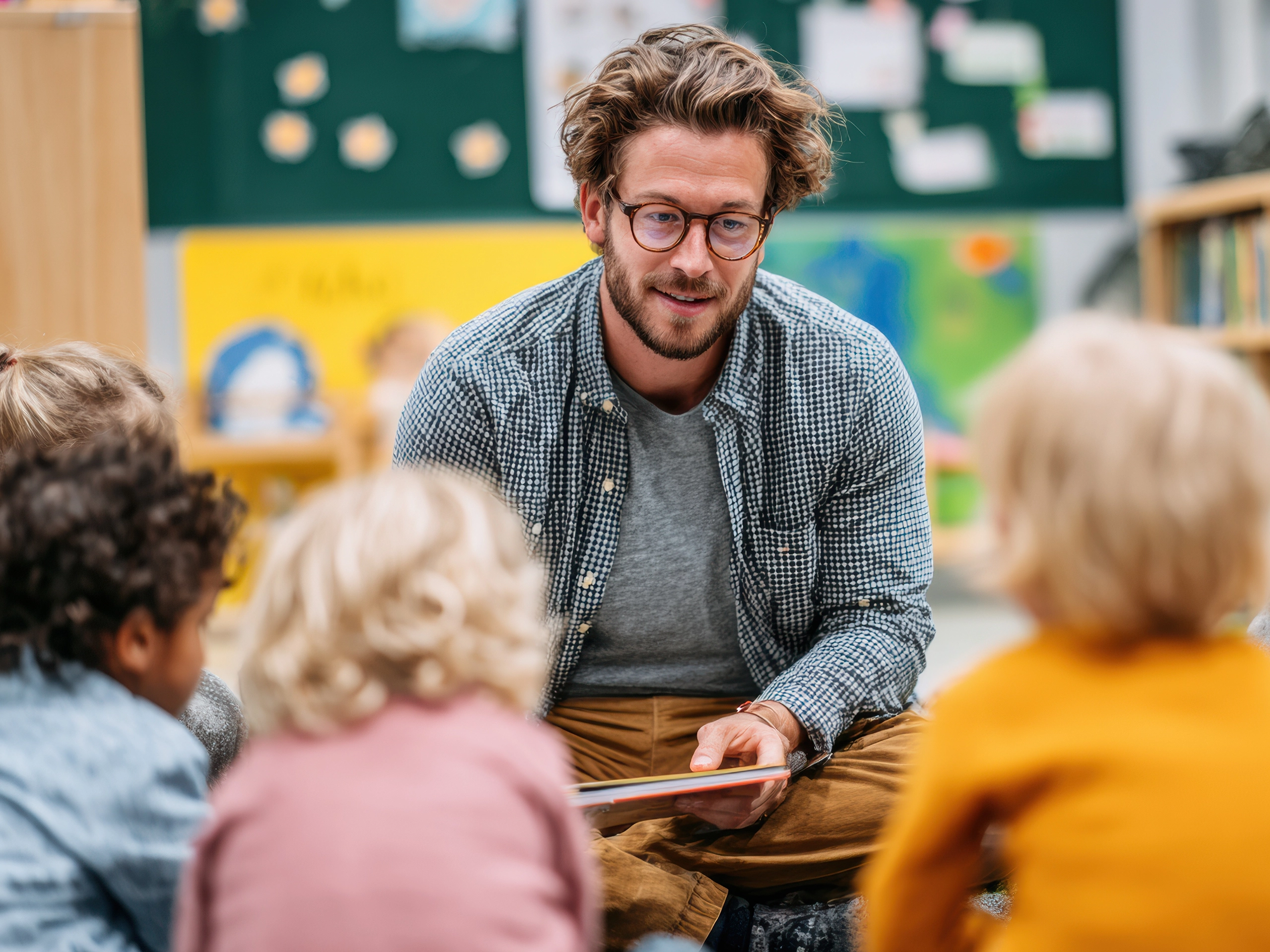 Childcare Worker Reads to Toddlers in Colorful Daycare Setting With Engaged Children in Late Afternoon Session