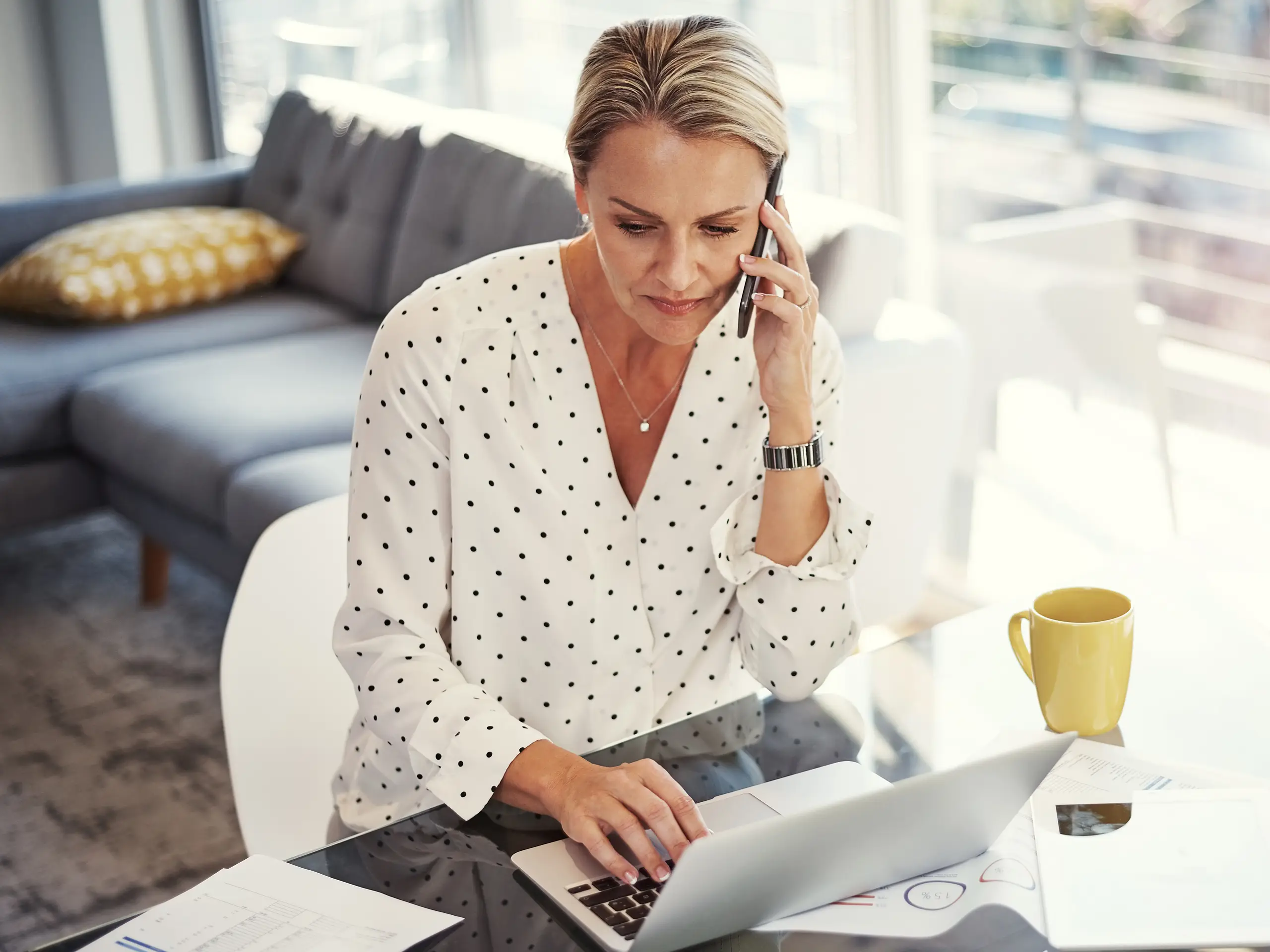 Woman talking on phone with laptop infront of her