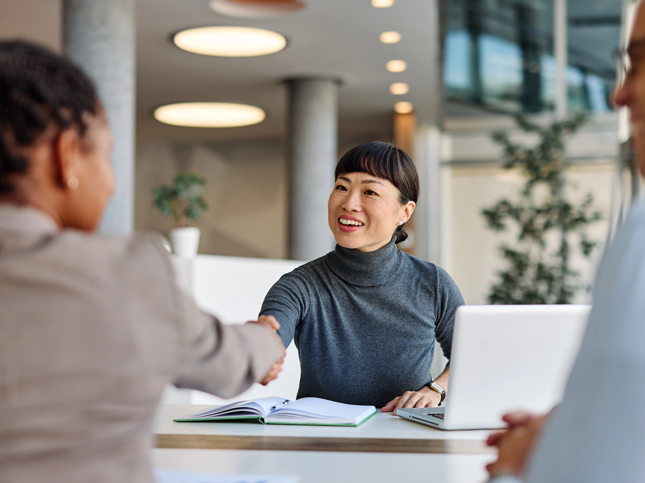 Group of young business people having a meeting shaking hands handshake introducing each other or making a deal agreement during meeting in the office. 