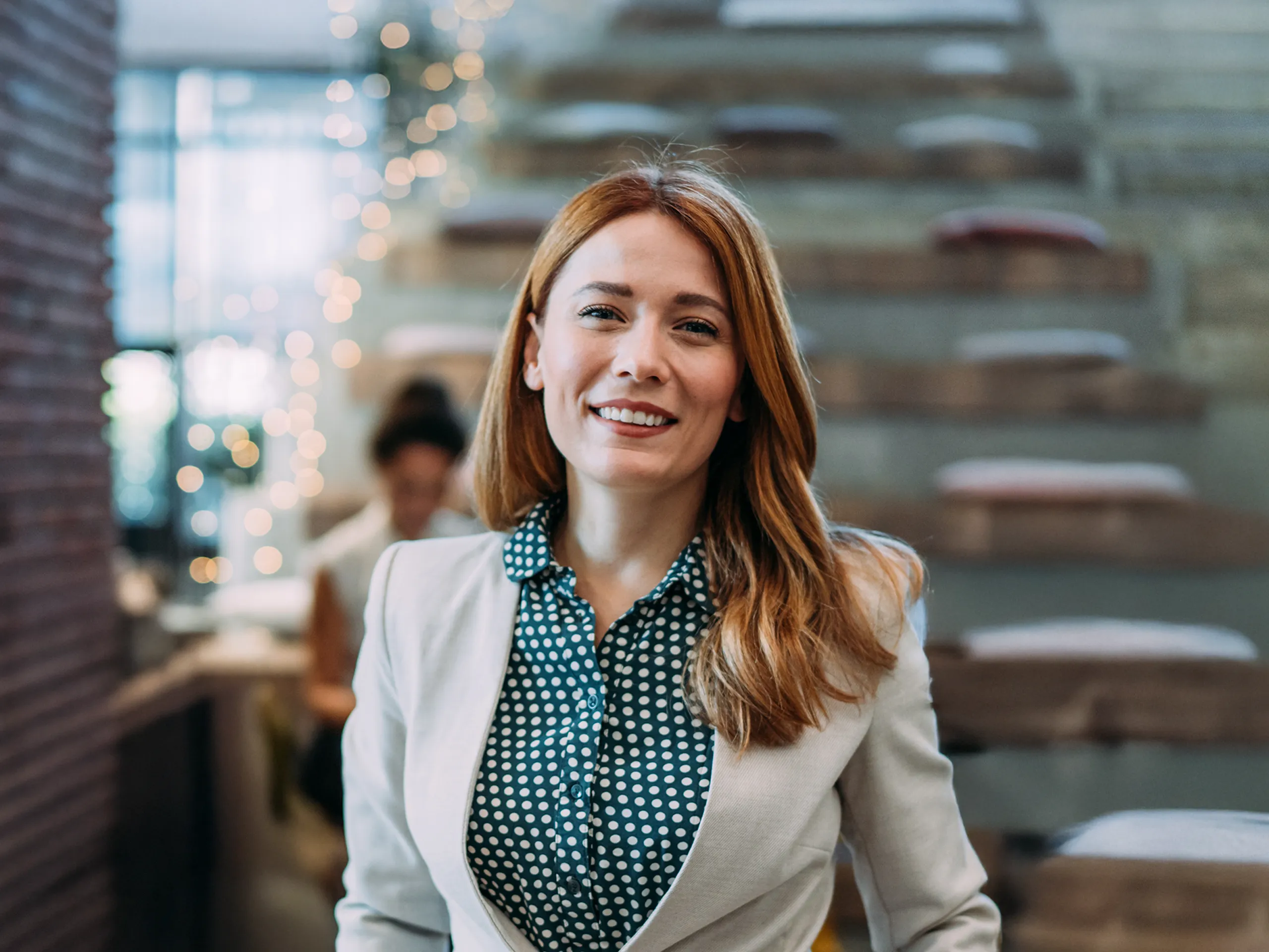 Smiling woman in business attire in a modern office.
