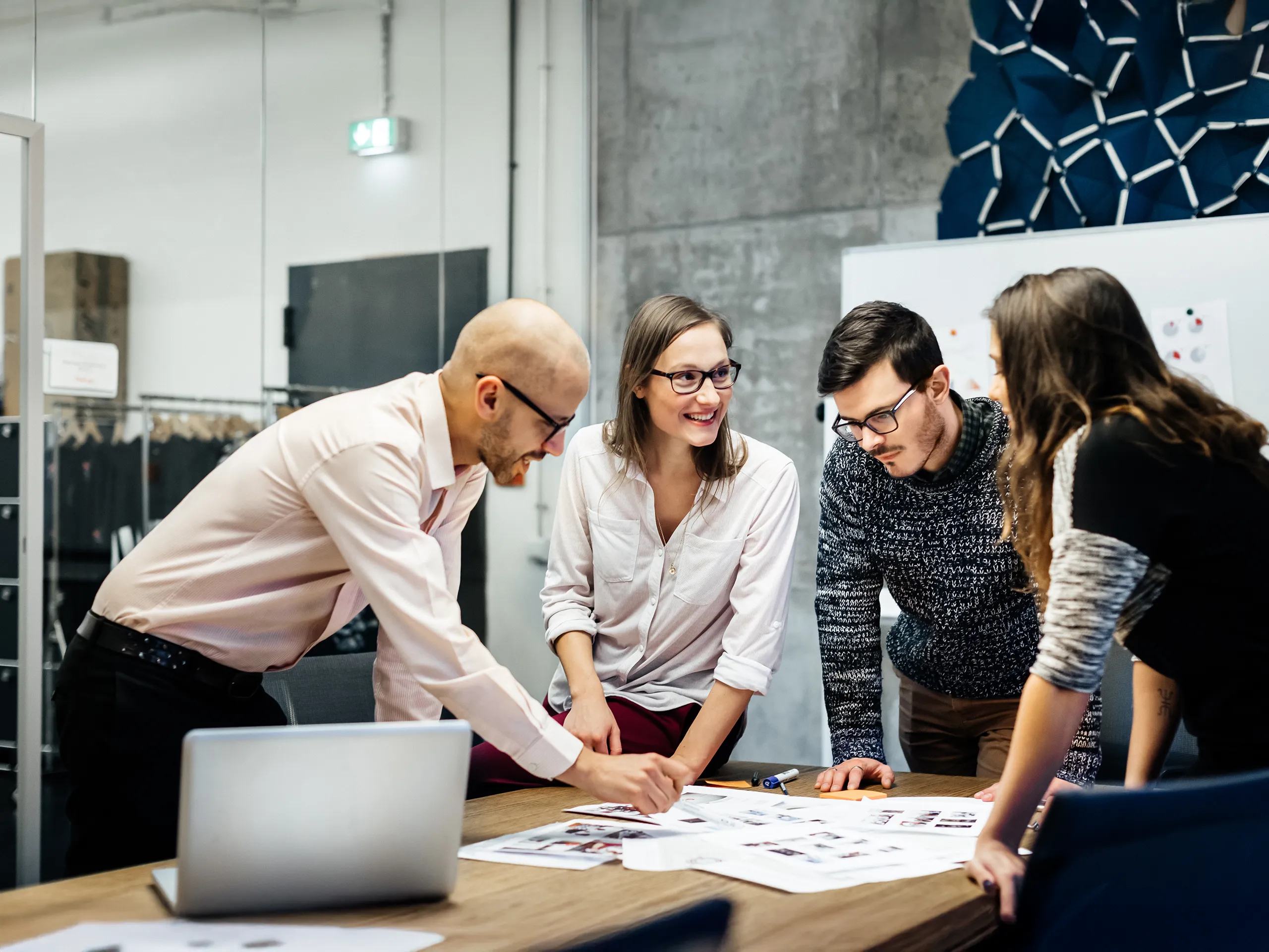 Team meeting with four people at a conference table.