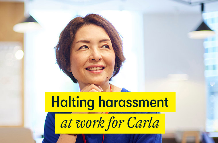 Halting harassment at work for Carla - a middle aged woman sits in an office looking happy