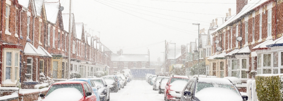 a snow covered street with cars