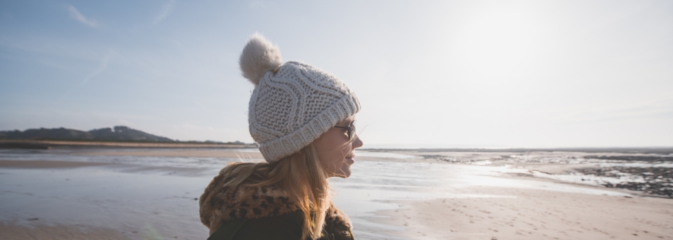 A woman looking into the distance on a beach