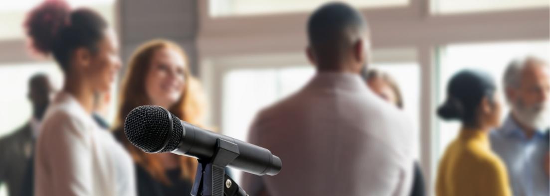 People attending a conference, microphone in focus