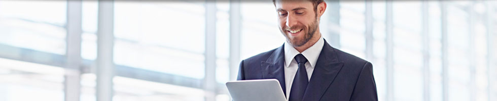 Recourse Options Banner 2 Young businessman with beard smiling at a tablet