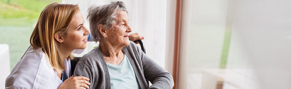 A woman and elderly woman looking out a window