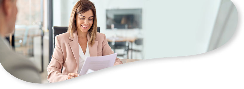 A woman smiling whilst looking at some paperwork