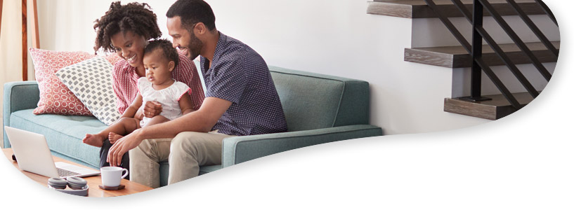 Happy family of three looking at a laptop 